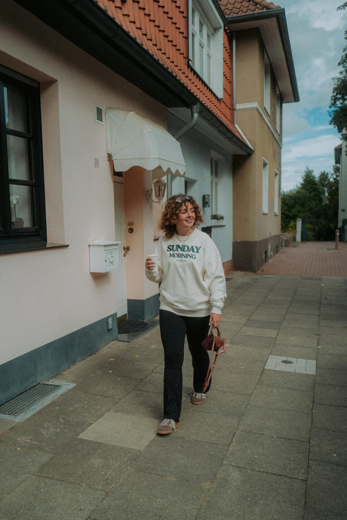 Oversized Damen Sweater in Creme getragen im Alltag mit Statement Print